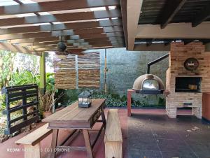 eine Terrasse mit einem Holztisch und einem Backofen im Freien in der Unterkunft Pátio Caiçara, Hospedagem, Eventos , Recepções in Paranaguá