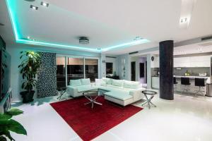 Lovely 3-Bed Apartment in Maho في Maho Reef: غرفة معيشة مع أريكة بيضاء وسجادة حمراء