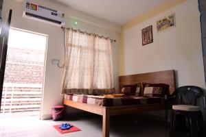 a bedroom with a bed in front of a window at Jankivihar Homestay at Prahladghat within 1km from Shri Ram Mandir in Ayodhya