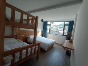 a bedroom with two bunk beds and a window at Huang Mountain Wangfeng Hotel in Huangshan City