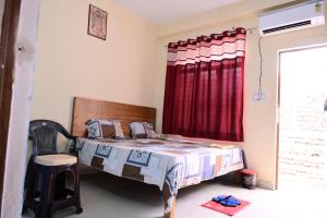 a bedroom with a bed and a red curtain at Jankivihar Homestay at Prahladghat within 1km from Shri Ram Mandir in Ayodhya