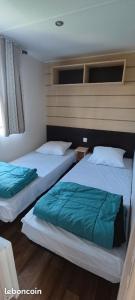 two beds in a room with at Village Vacances 4 etoiles LES MATHES AUX CHARMETTES in Les Mathes