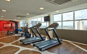 a gym with several tread machines in a room with windows at FLATS - DUO JK in Sao Jose do Rio Preto