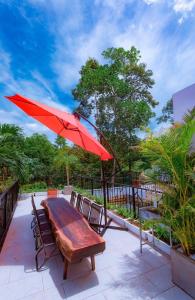 - une table et des chaises avec un parasol rouge sur la terrasse dans l'établissement Hilly Villa Hue, à Cư Chinh