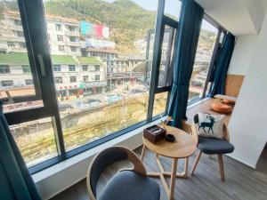 Pokój ze stołem i krzesłami oraz dużym oknem w obiekcie Huang Mountain Wangfeng Hotel w mieście Huangshan