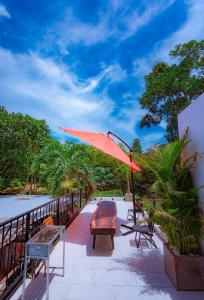 um pátio com um guarda-sol, uma mesa e cadeiras em Hilly Villa Hue em Cư Chinh