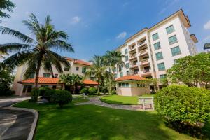 a large apartment building with a lawn and palm trees at Diamond Westlake Suites in Hanoi