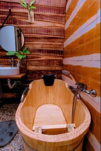 La salle de bains est pourvue d'une baignoire en bois et d'un lavabo. dans l'établissement Hilly Villa Hue, à Cư Chinh