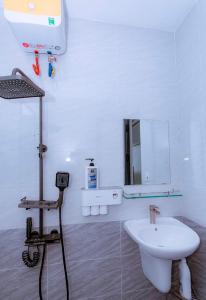 La salle de bains blanche est pourvue d'un lavabo et d'un miroir. dans l'établissement Hilly Villa Hue, à Cư Chinh