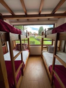 two bunk beds in a room with a large window at Hacienda Le Plus in Quito