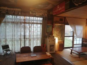 uma sala de jantar com uma mesa e uma guitarra num quarto em Yukiumi House em Kamikawa