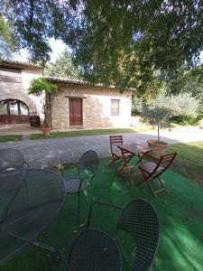 een patio met tafels en stoelen in een tuin bij All'Ombra di San Damiano in Assisi