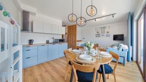 a kitchen and dining room with a table and chairs at Apartamenty Sun & Snow Foka in Hel