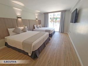 Habitación de hotel con 2 camas y ventana en Hotel Margarita Dynasty en Porlamar