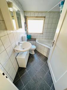 a bathroom with a sink and a toilet and a tub at Wohnung in Oberesslingen