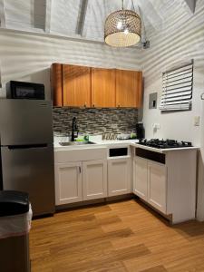 a kitchen with white cabinets and a sink and a refrigerator at Northside Studio Vacation Rental in Nazareth