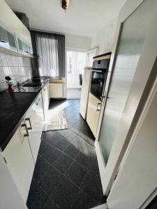 a kitchen with white appliances and black tile floors at Wohnung in Oberesslingen