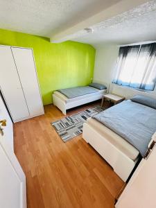 a bedroom with two beds and a green wall at Wohnung in Oberesslingen