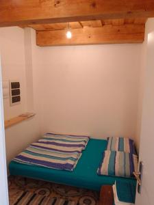 a small bed in a room with a wooden ceiling at Chata U Jirky 