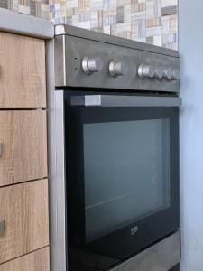 a black oven in a kitchen with wooden cabinets at Cleopatra's Cozy Cottage in Keramoti +13 photos