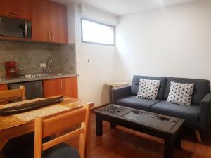 salon z niebieską kanapą i stołem w obiekcie Apartaestudios La Candelaria w mieście Bogota