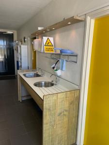 a bathroom with two sinks and a caution sign on the wall at The blue lady in Sleen