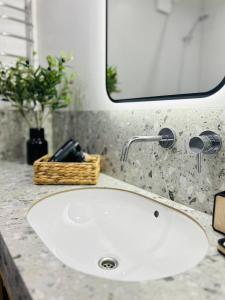 un lavandino bianco in un bagno con specchio di Апартаменти в центрі на Проскурівського Підпілля a Chmel'nyc'kyj