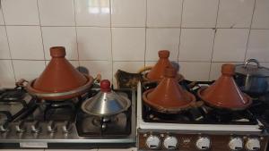 a group of pots and pans sitting on top of a stove at Riad Auberge Bassou in Nkob