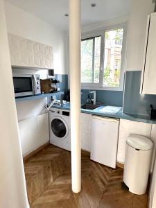 a kitchen with a washing machine and a microwave at Le Chalgrin in Paris
