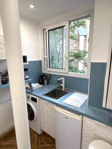 a kitchen with a sink and a washing machine at Le Chalgrin in Paris