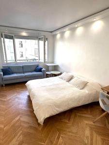 a bedroom with a large bed and a couch at Le Chalgrin in Paris