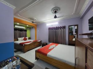 a hotel room with two beds and a television at Abhishek Inn New Digha in Digha