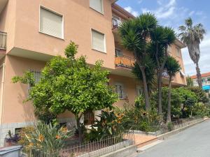 a building with palm trees in front of it at New apartment next to the sea in Bordighera