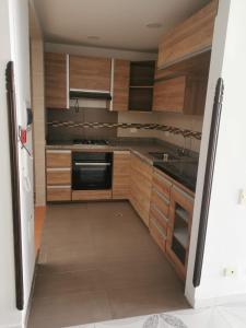 eine Küche mit Holzschränken, einer Spüle und einem Kühlschrank in der Unterkunft Casa en curiti in Curití