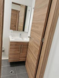 ein Badezimmer mit einem Waschbecken und einer Holztür in der Unterkunft Casa en curiti in Curití