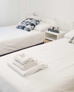 two beds with white towels on top of them at Arboleda Centro in Soria