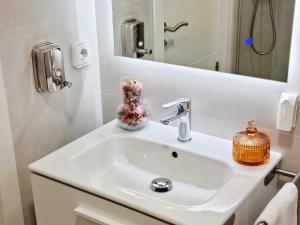 La salle de bains est pourvue d'un lavabo blanc et d'un miroir. dans l'établissement Arboleda Centro, à Soria