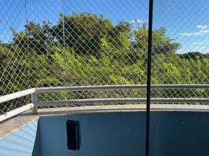 a chain link fence on a bridge with trees at Águas da Serra Apart hotel in Rio Quente +2 photos