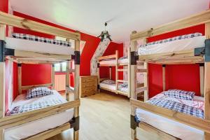 eine Gruppe Etagenbetten in einem Zimmer mit roten Wänden in der Unterkunft La Graviere - 28pers - swimming pool pétanque billiards in Fontenay-Trésigny