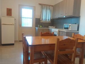 a kitchen with a table and chairs and a refrigerator at BOSCO VERDE Corfu Apartments in Gouvia +37 photos