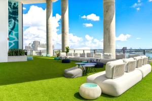 a rooftop patio with grass and white furniture and columns at Exquisite Bay View Studio at Downtown Miami in Miami