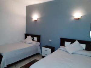 a bedroom with two beds and two lights on the wall at Relaxing apartment overlooking the sea and 2 terrace on the sea in Quseir