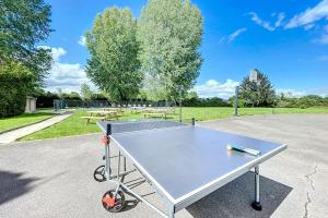 a ping pong table sitting in a parking lot at La Graviere - 28pers - swimming pool pétanque billiards in Fontenay-Trésigny