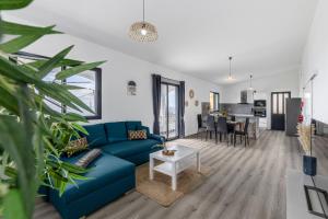 un soggiorno con un divano blu e un tavolo di Maylily Seascape Villa a Santa Cruz
