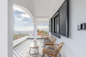 un balcone con sedie e vista sull'oceano di Maylily Seascape Villa a Santa Cruz