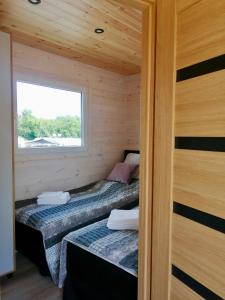 2 łóżka w małym pokoju z oknem w obiekcie sunset cabin on the beach w mieście Wapnica