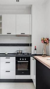 a kitchen with white cabinets and a black oven at Turegatan Top Class Apartment in Stockholm