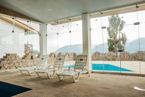 una habitación con sillas y una piscina en Hotel Puerta del Sol Colca, en Yanque