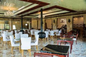 a restaurant with white chairs and tables and a fireplace at Hotel Puerta del Sol Colca in Yanque