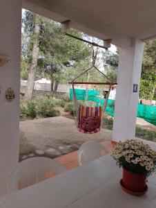 - une balançoire sur une terrasse couverte avec une table et des chaises dans l'établissement Casa Refugio Entre Pinos y Romeros, à Mogente